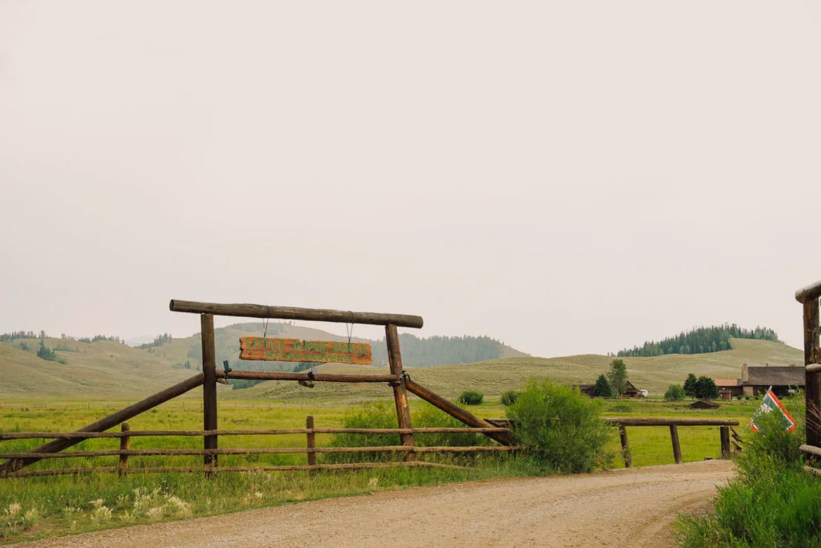 The ranch entrance gate framing the Teton Valley pasture