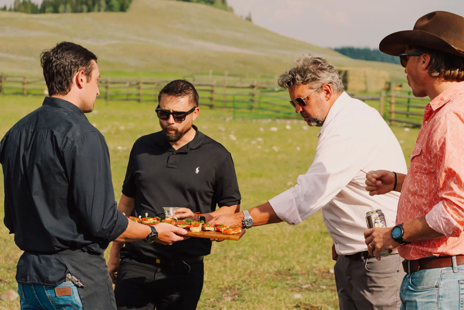 Guests sharing an appetizer and drinks out in the pasture