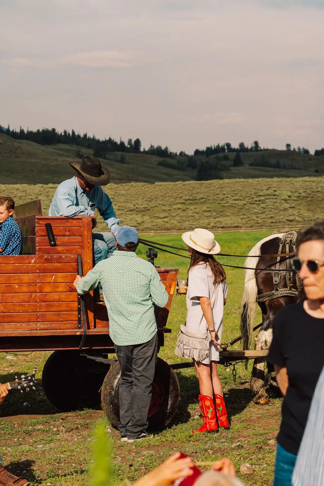 Guests riding a horse-drawn wagon across the ranch