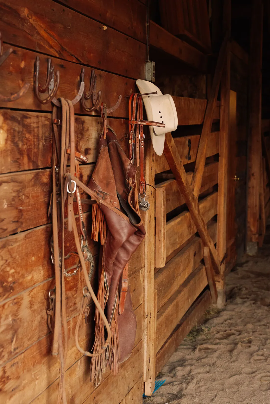 Saddles, bridles, and a cowboy hat in the ranch tack room