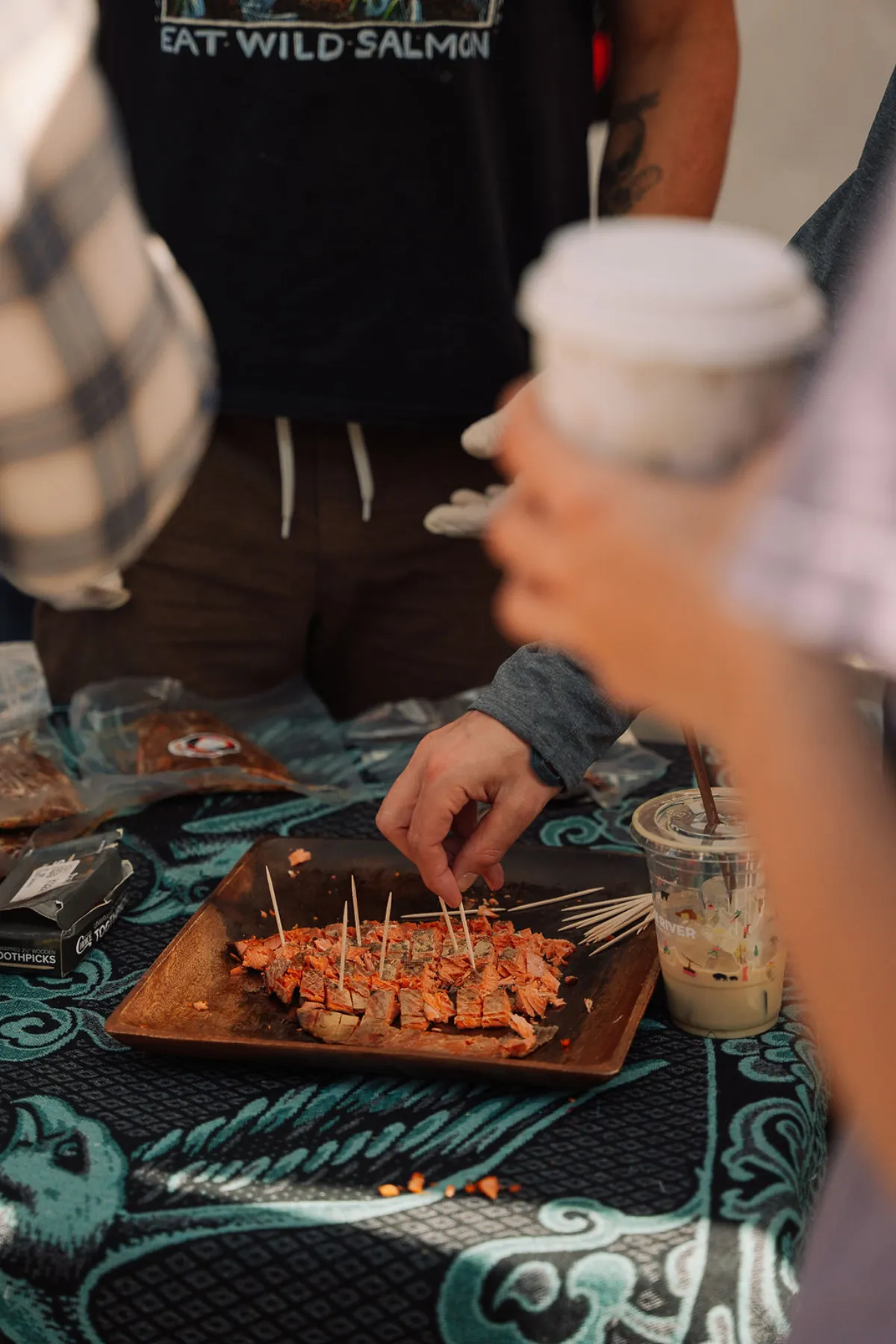 Wild salmon samples on a wooden board at a vendor booth