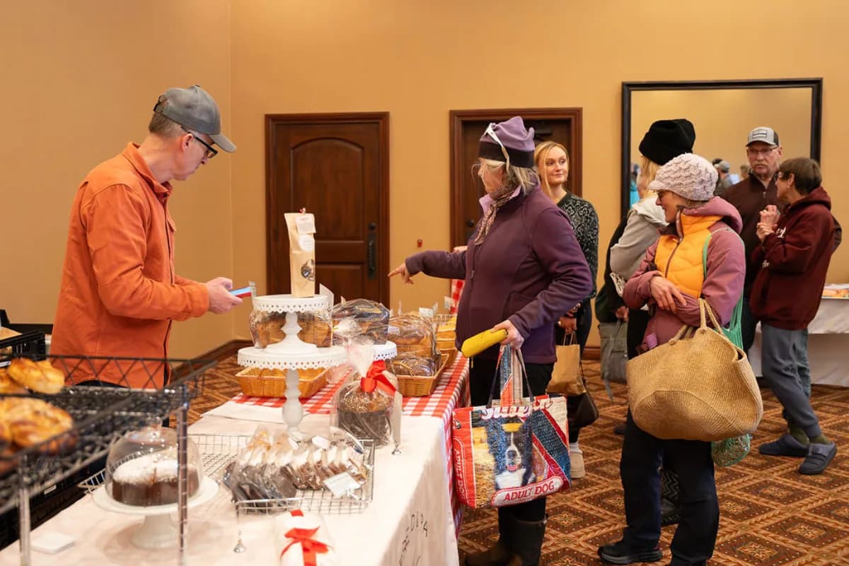 Shoppers browsing baked goods at the winter market bakery booth