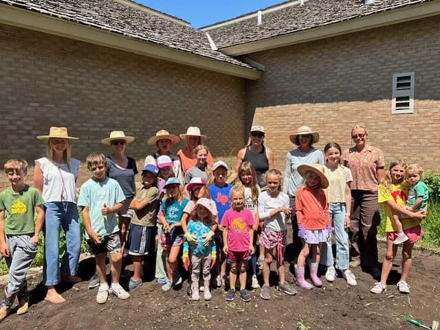 Students and volunteers gather for a group photo at the community garden