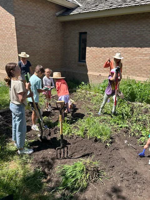 Children working together to dig and prepare garden beds