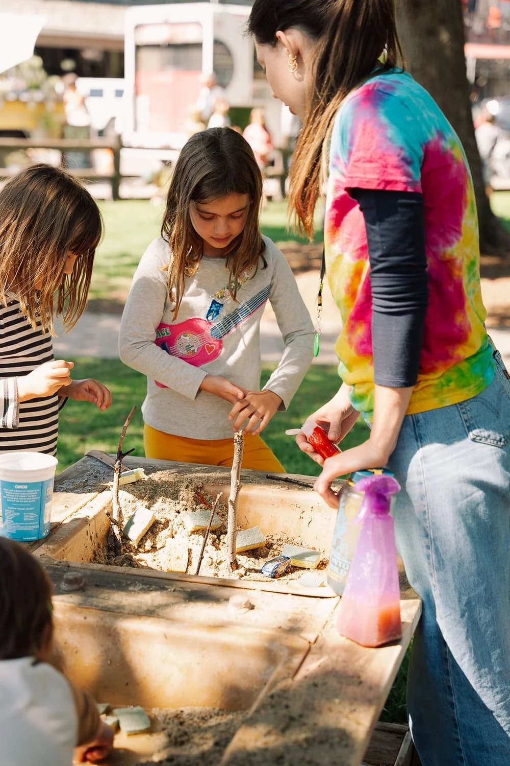 An educator and market-goers around a Discovery Sessions table