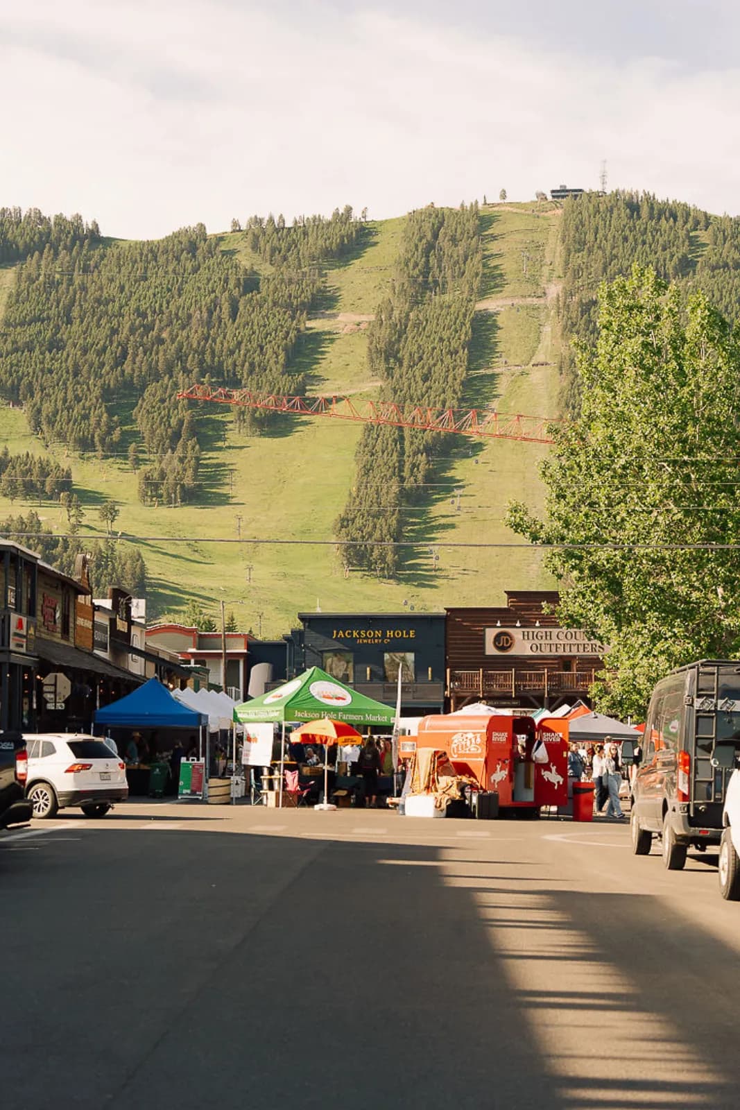 Market tents along the street below the green run of Snow King Mountain