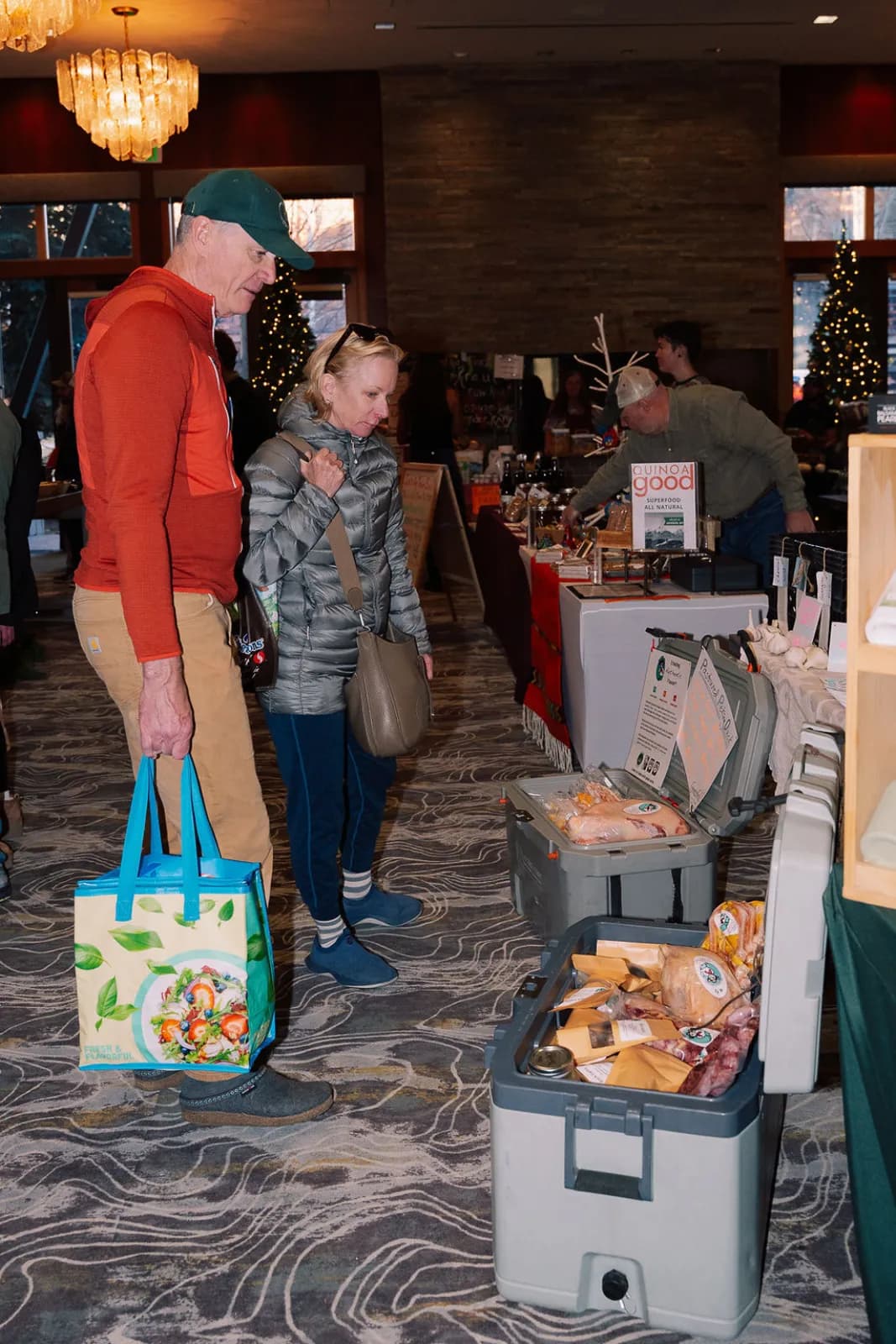 A family shopping among the booths and holiday lights at the winter market