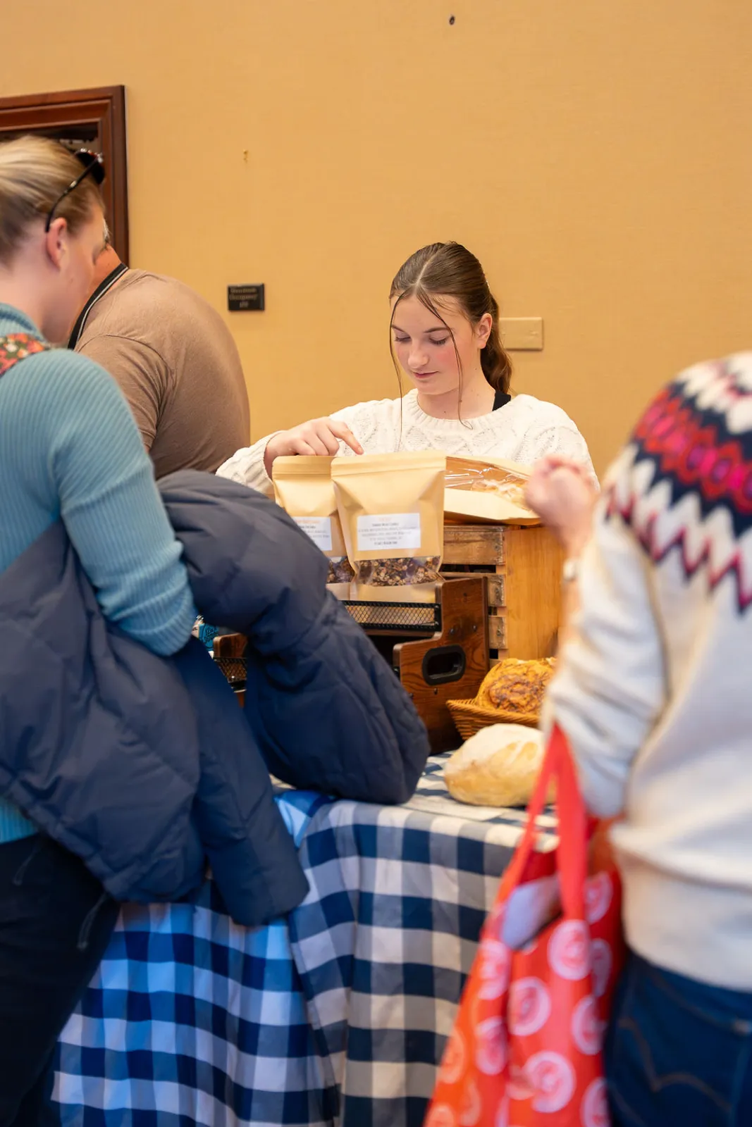 A vendor handing over bags of fresh bread at the winter market