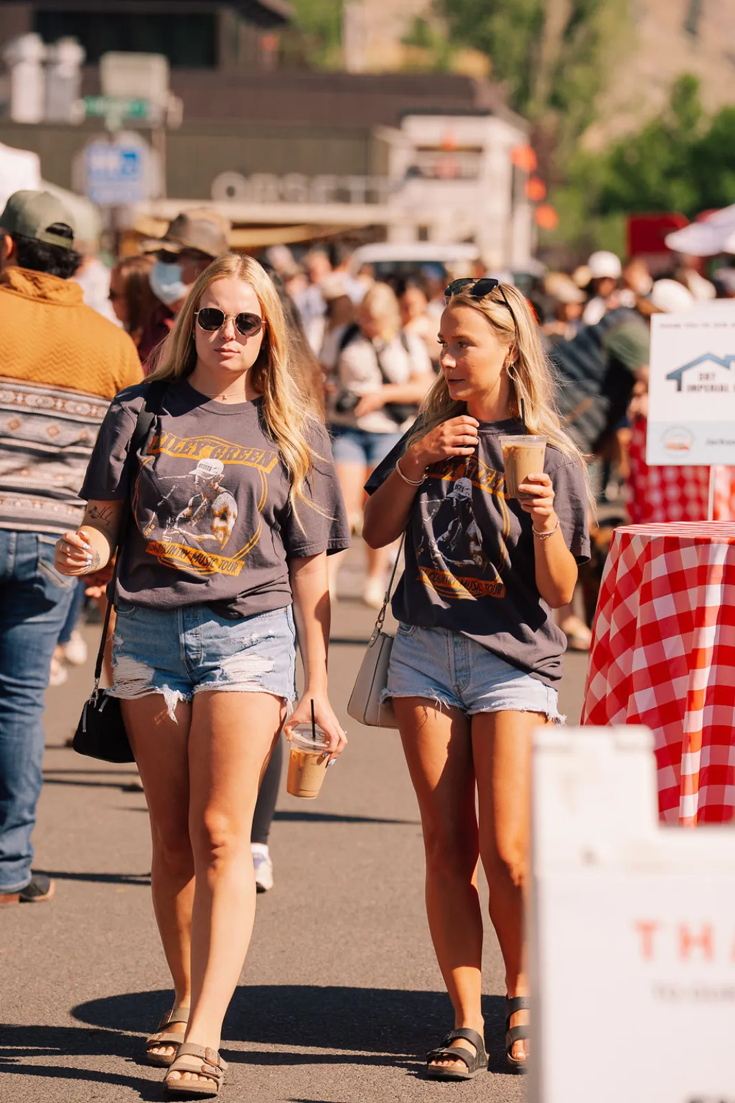 Two shoppers walking the sunny market street