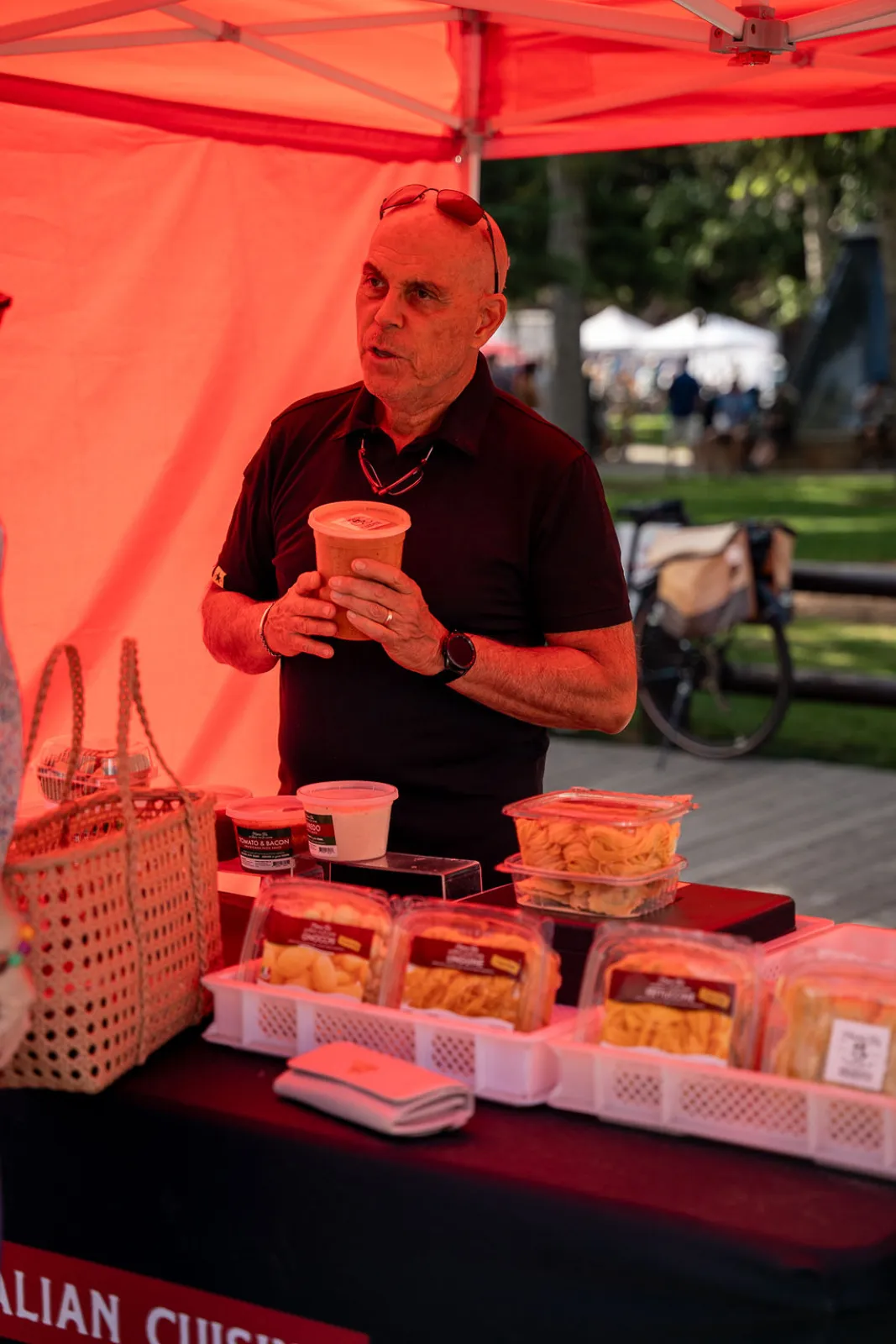 An Italian food vendor with a coffee at a warmly lit stand